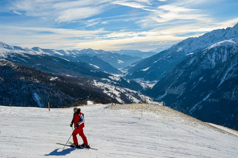 Skier descending a snowy slope in the Swiss Alps