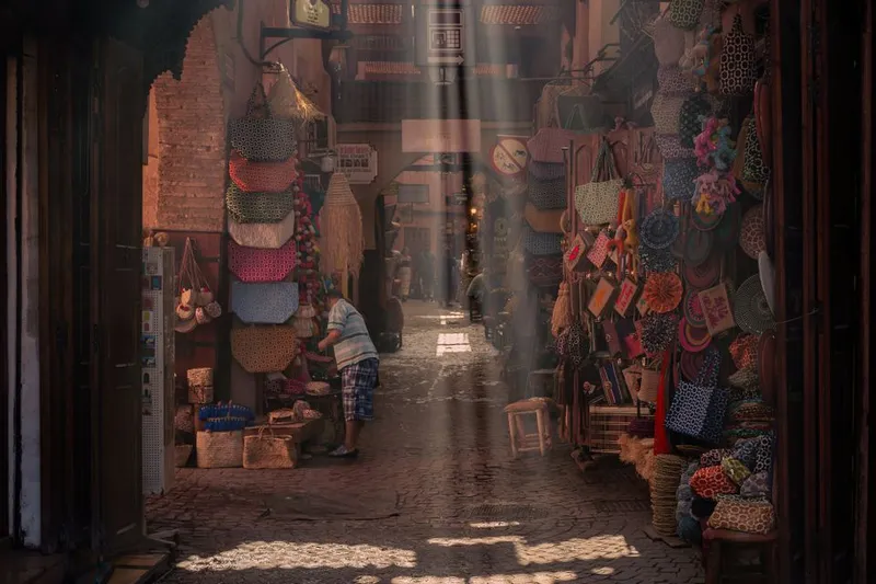 Sunlit market stalls along a narrow Marrakech street