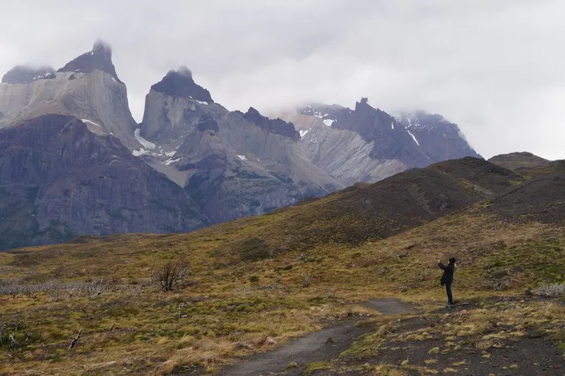 Hiker below the mountains of Torres del Paine in Patagonia