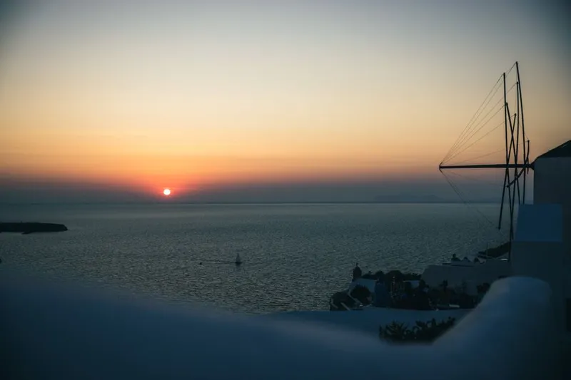 Sailing boat at sunset off the coast of Santorini