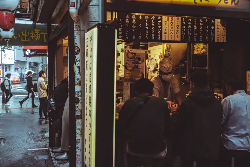People at an illuminated street food stall in Tokyo